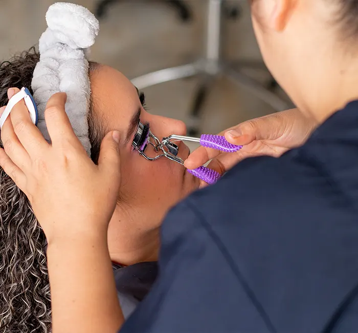 Professional Makeup Artist Curling a Woman Eyelashes